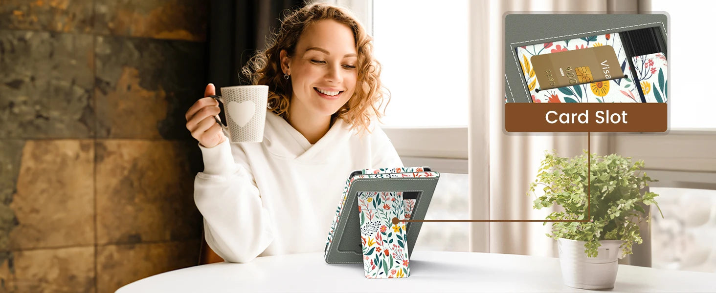 Woman holding a mug with a tablet displaying a card slot and a colorful cup on a table.