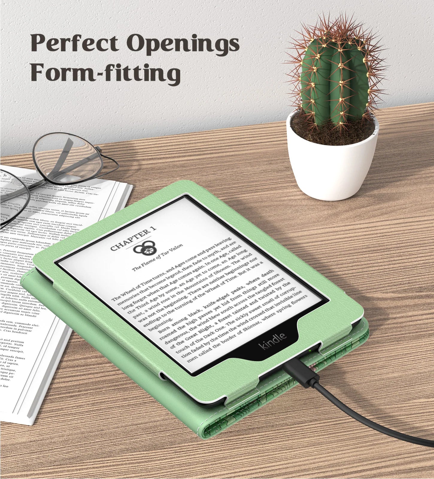 GreenKindle case on a Kindle device with text 'Perfect Openings Form-fitting' above, on a wooden surface with a cactus and glasses.